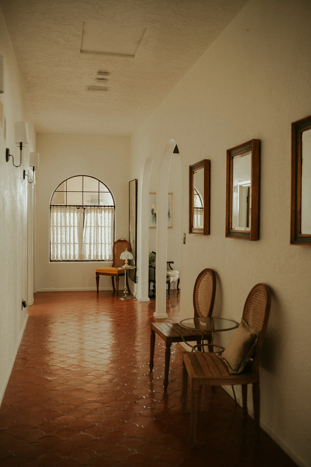 about-us-02 a-hallway-with-a-chair-and-a-table-in-it-30rzzhejjgq