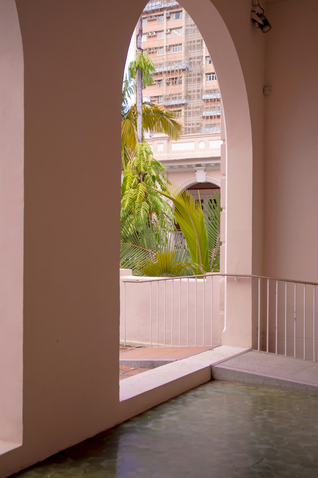 heros-img a-view-of-a-pool-through-an-arch-in-a-building-d-jflwuown0